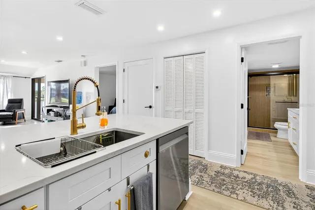 a kitchen with stainless steel appliances granite countertop a sink and a refrigerator
