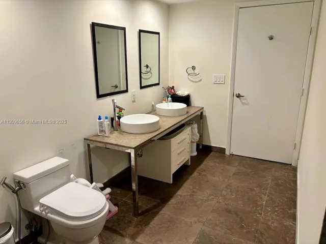 a bathroom with a toilet sink and mirror