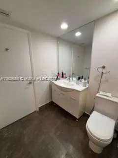a bathroom with a sink mirror and toilet