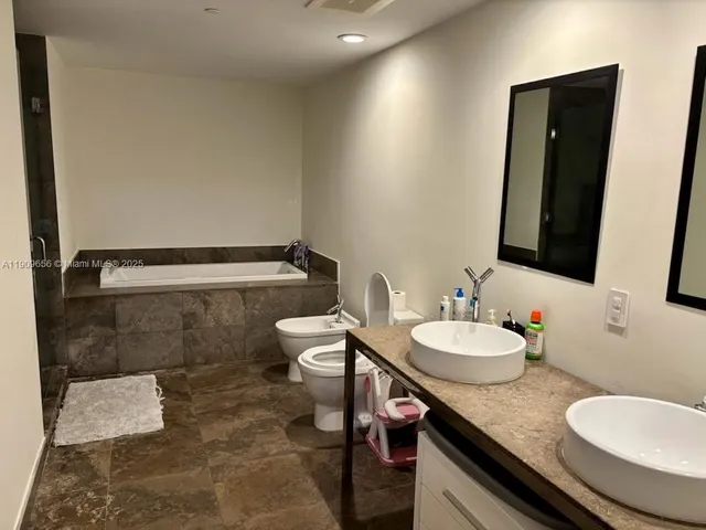 a bathroom with a granite countertop toilet sink and mirror
