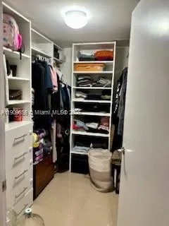 a view of walk in closet with clothes and shoes