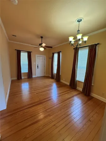 a view of a hallway with wooden floor and stairs