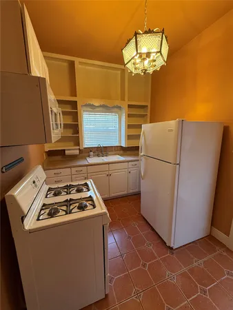 a kitchen with a sink a refrigerator and cabinets