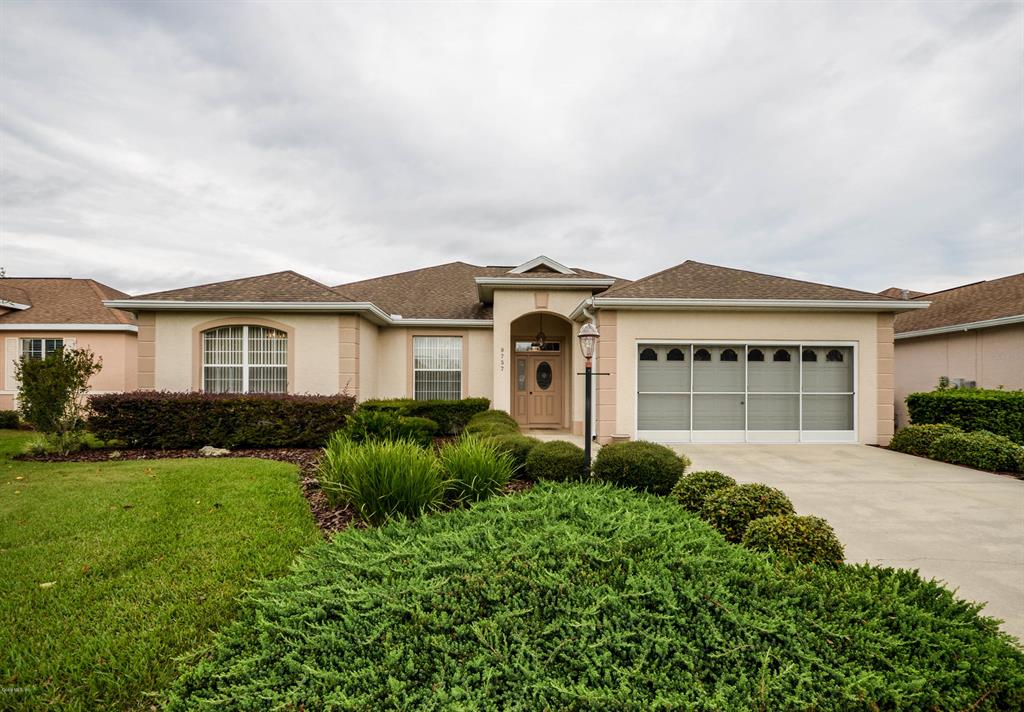 9757 Southwest 89th Loop Ocala, FL 34481 - Photo 1 of 1 a front view of a house with garden