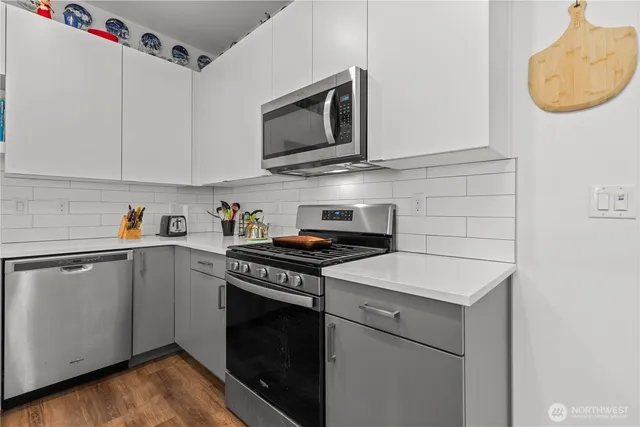 a kitchen with stainless steel appliances a stove a microwave and cabinets