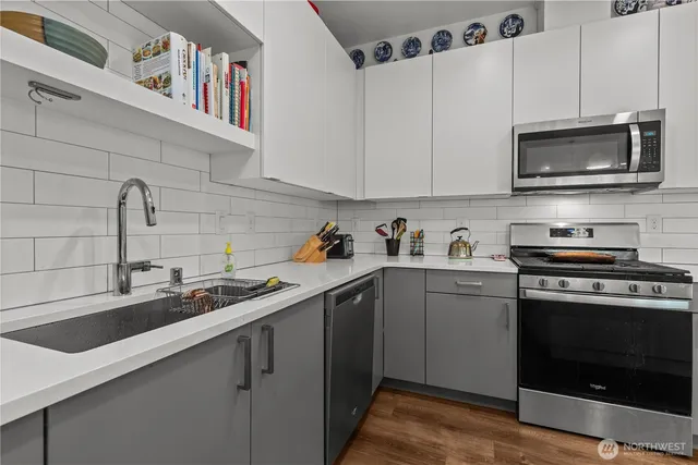a kitchen with cabinets stainless steel appliances and a sink