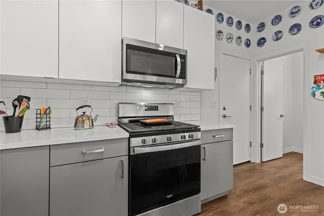 a kitchen with stainless steel appliances a stove a microwave and cabinets