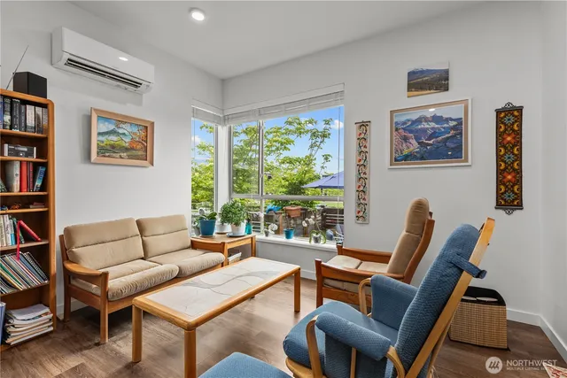 a living room with furniture a bookshelf and a large window