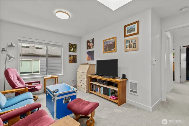 a living room with furniture a flat screen tv and a window