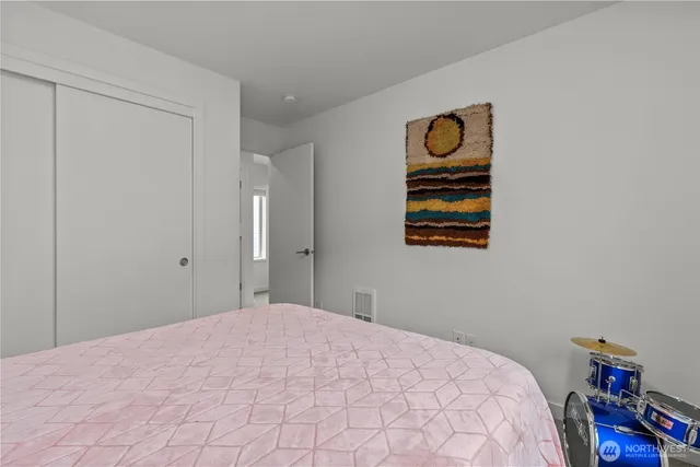 a bedroom with a bed and a painting on the wall