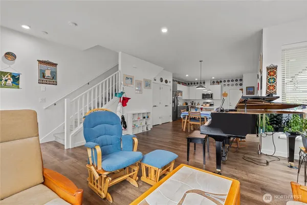 a living room with furniture kitchen view and a large window