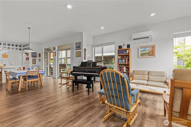 a living room with furniture a piano and a bookshelf