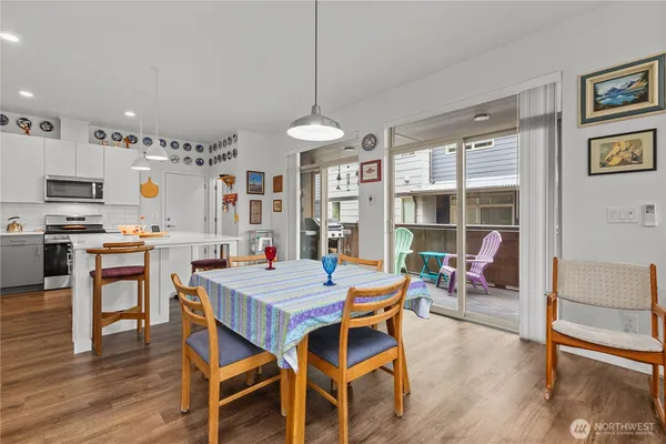 a dining room with wooden floor a chandelier a wooden table and chairs
