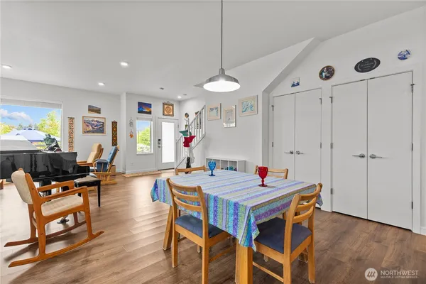 a dining room with wooden floor a chandelier a wooden table and chairs
