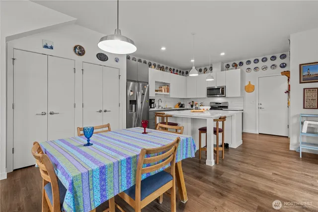 a kitchen that has a table chairs and a refrigerator