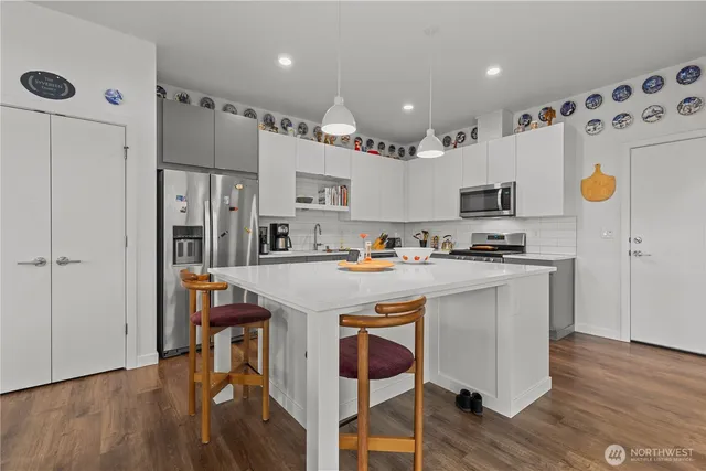 a kitchen with granite countertop a stove a sink and a refrigerator
