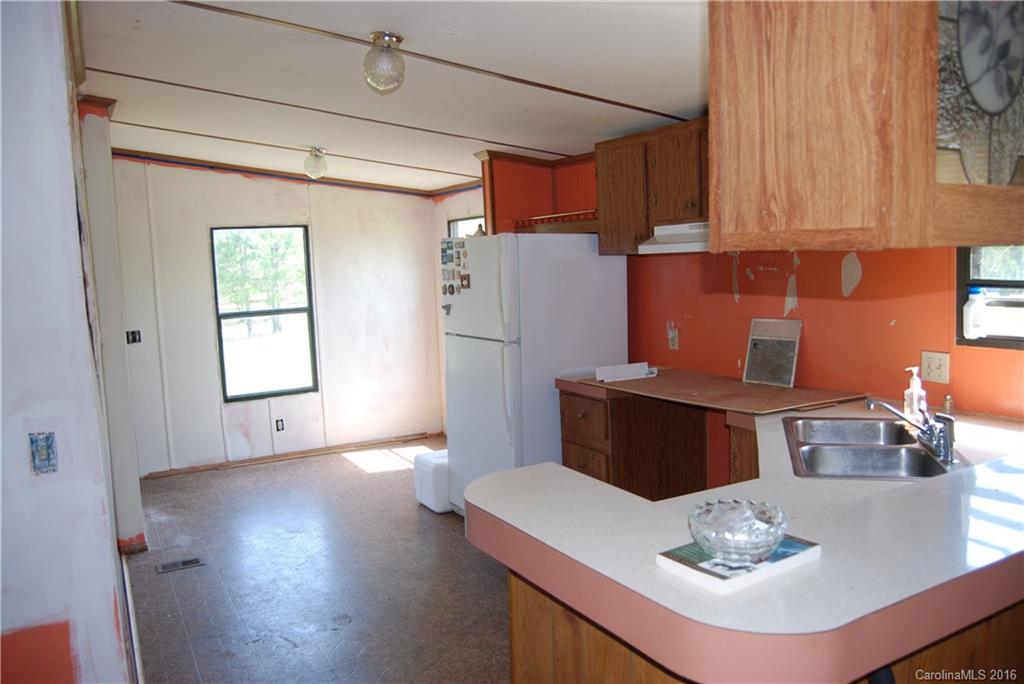 3224 Belk Mill Road Wingate, NC 28174 - Photo 9 of 13 a kitchen with stainless steel appliances granite countertop a sink dishwasher and a refrigerator with wooden floor