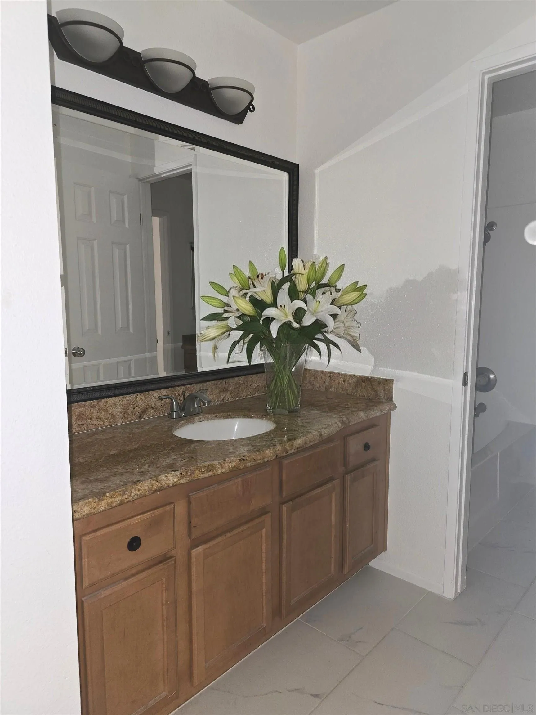 1130 West Blaine Street, Unit 204 Riverside, CA 92507 - Photo 12 of 24 a bathroom with a granite countertop sink and a mirror