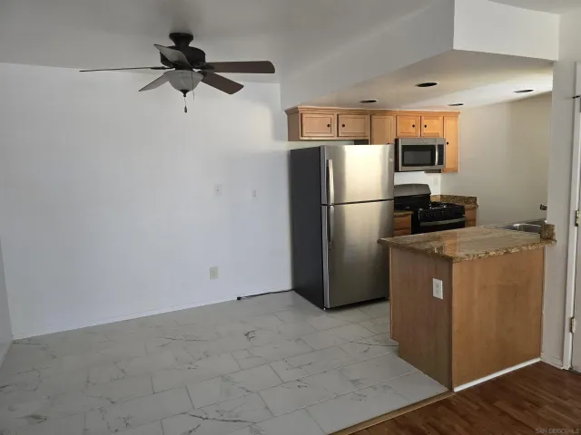 a kitchen with a refrigerator a microwave and cabinets