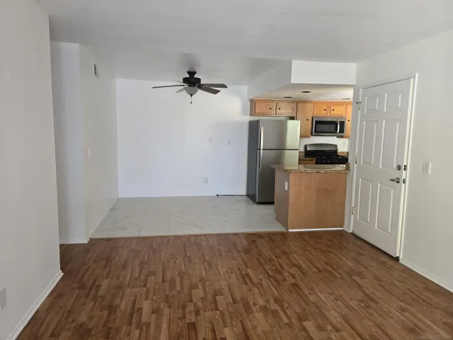 a view of a kitchen with a sink refrigerator and wooden floor