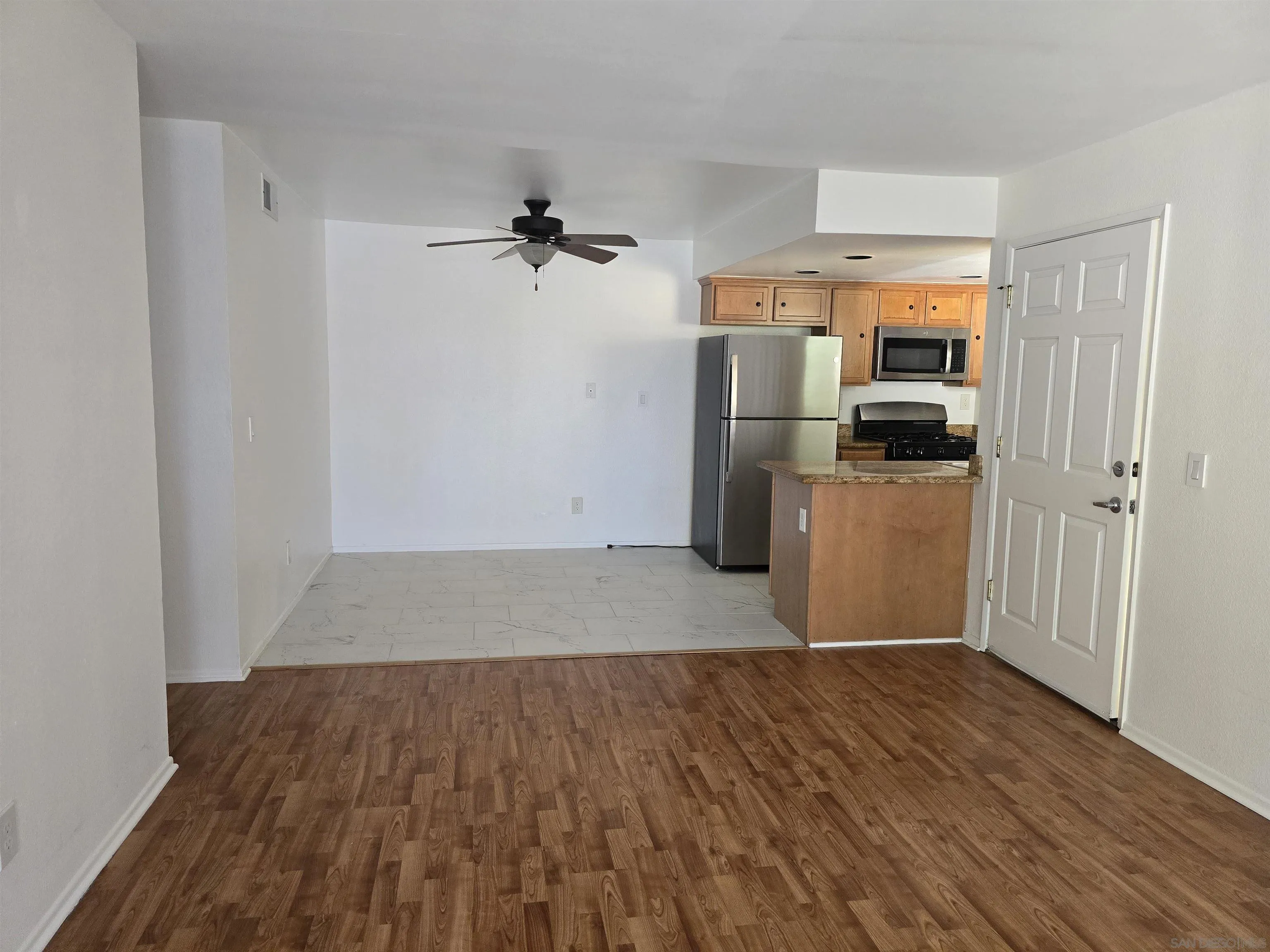 1130 West Blaine Street, Unit 204 Riverside, CA 92507 - Photo 9 of 24 a view of a kitchen with a sink refrigerator and wooden floor