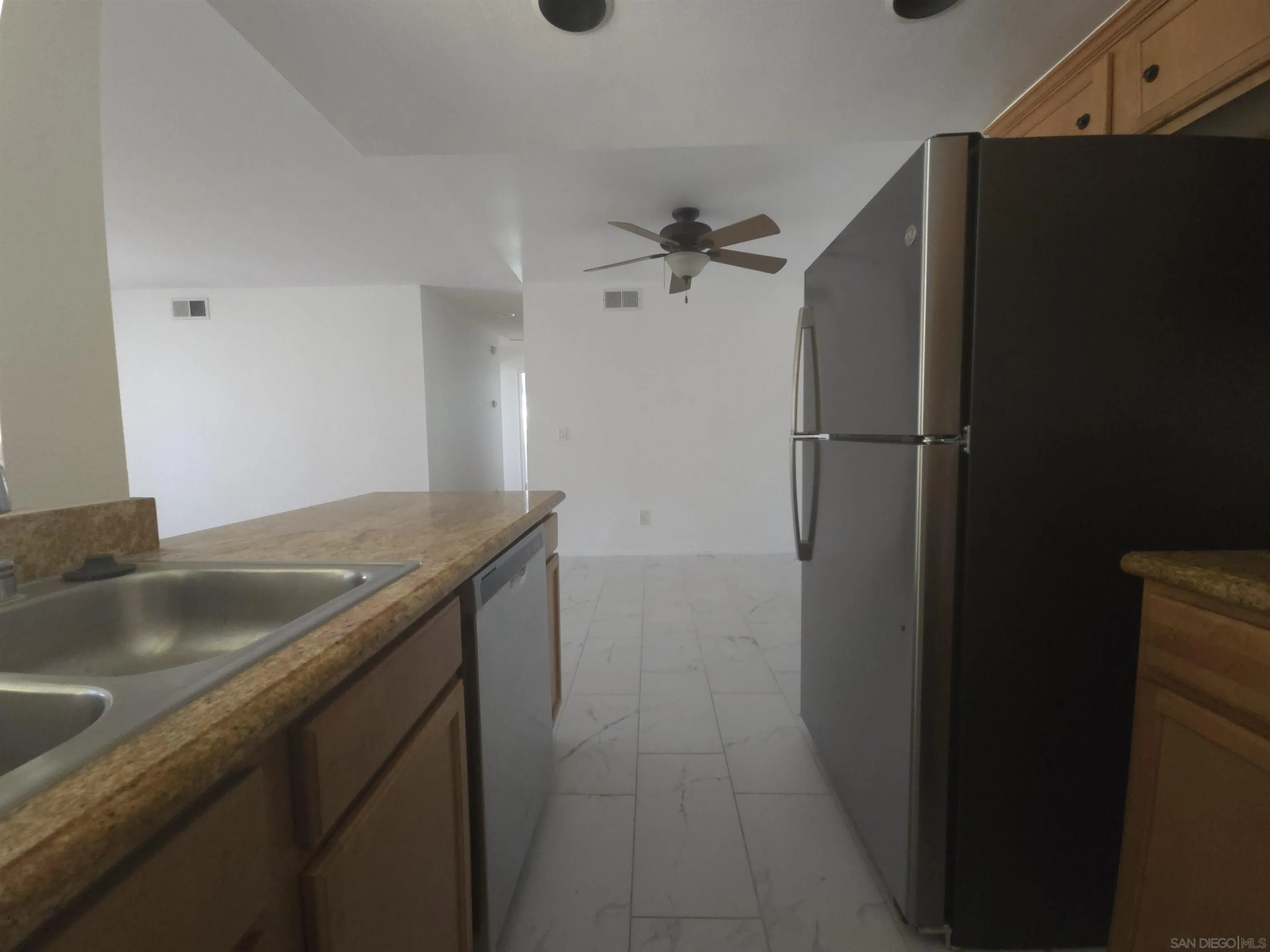 1130 West Blaine Street, Unit 204 Riverside, CA 92507 - Photo 10 of 24 a kitchen with a granite counter top and a refrigerator