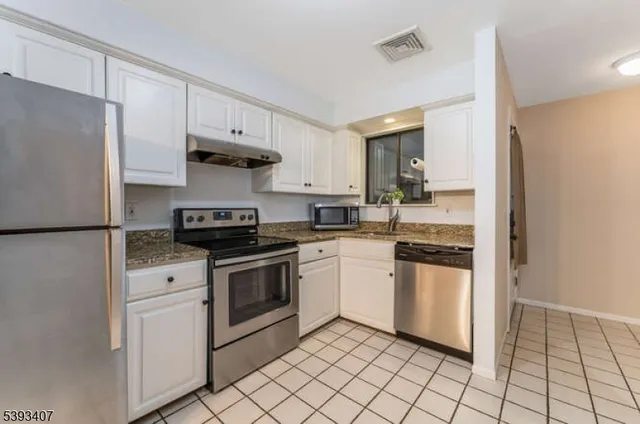 a kitchen with stainless steel appliances granite countertop a stove a refrigerator and a refrigerator