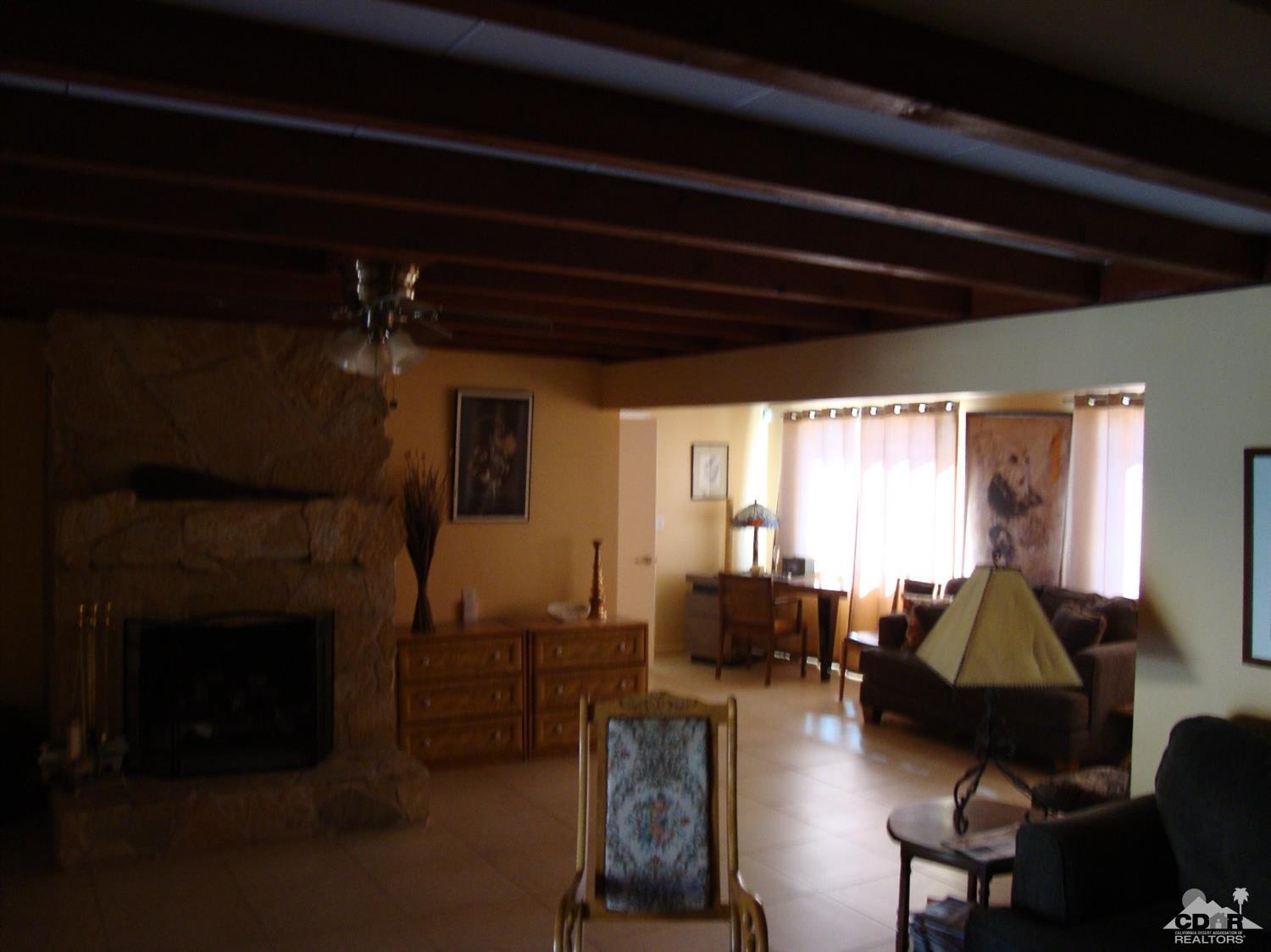 66671 San Rafael Road Desert Hot Springs, CA 92240 - Photo 12 of 36 a living room with furniture a fireplace and a flat screen tv