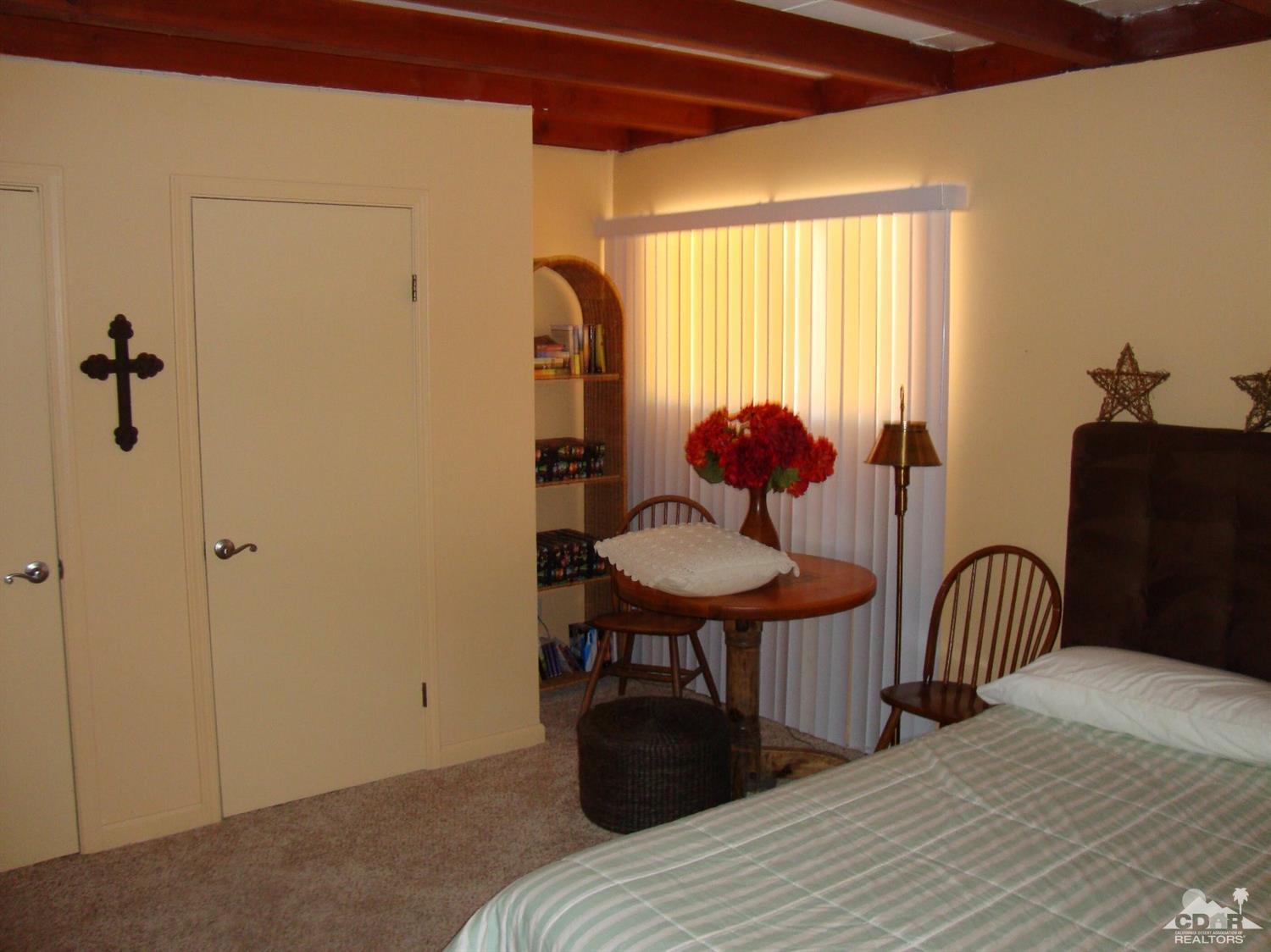 66671 San Rafael Road Desert Hot Springs, CA 92240 - Photo 20 of 36 a bedroom with a bed and a chandelier