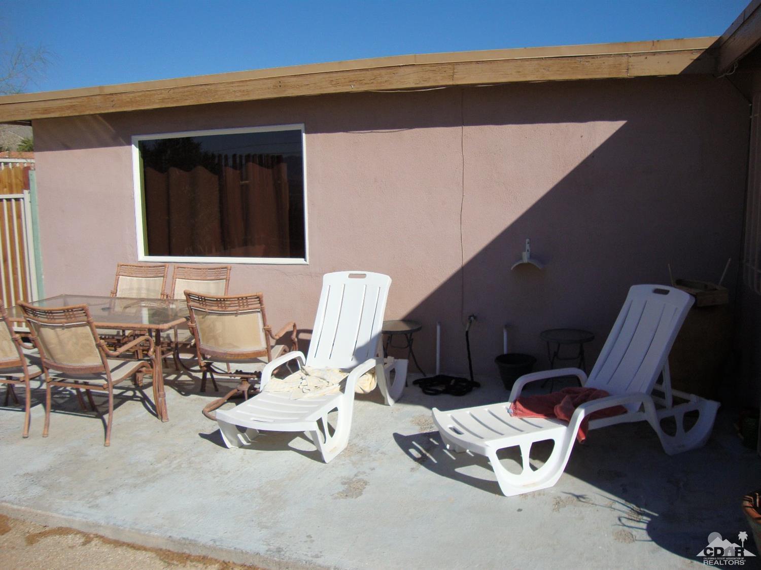 66671 San Rafael Road Desert Hot Springs, CA 92240 - Photo 28 of 36 a view of a chairs and table in backyard