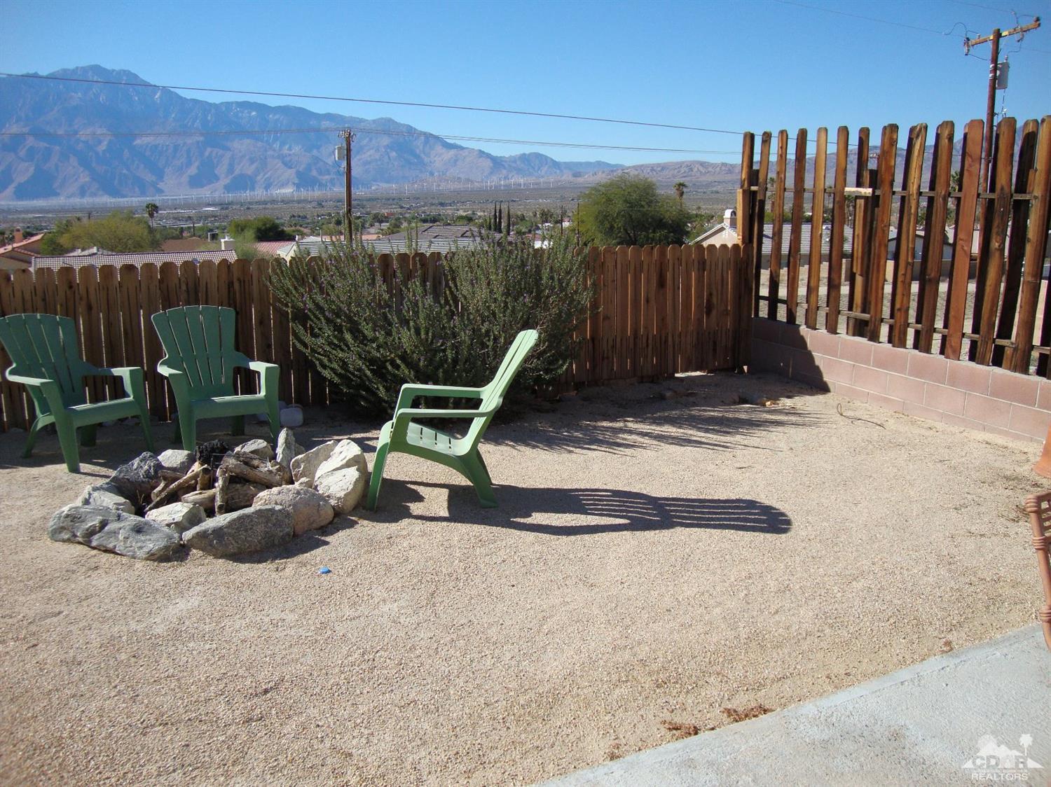 66671 San Rafael Road Desert Hot Springs, CA 92240 - Photo 29 of 36 a view of a backyard with a chair and potted plants