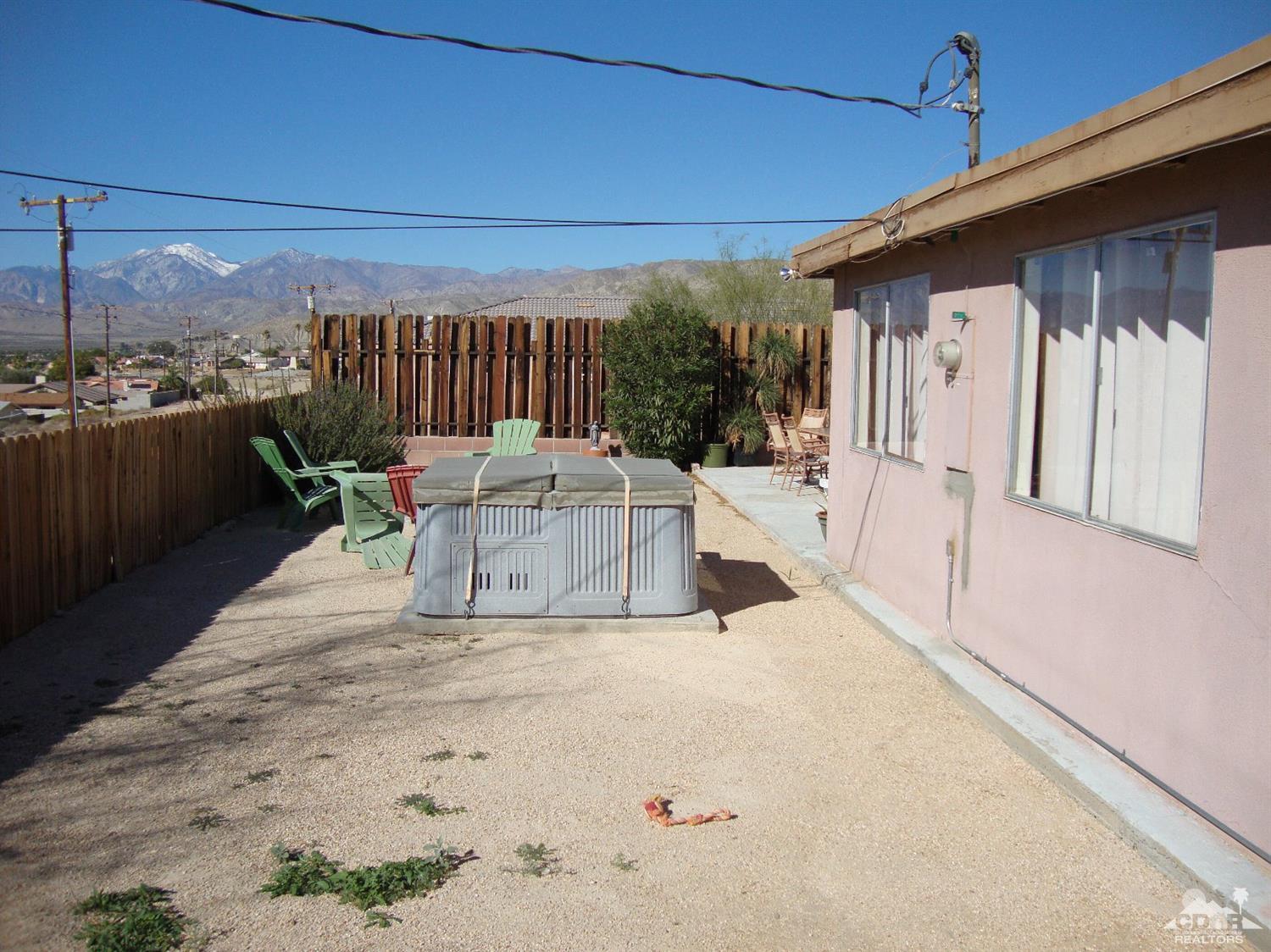 66671 San Rafael Road Desert Hot Springs, CA 92240 - Photo 31 of 36 a view of a patio with table and chairs with wooden floor