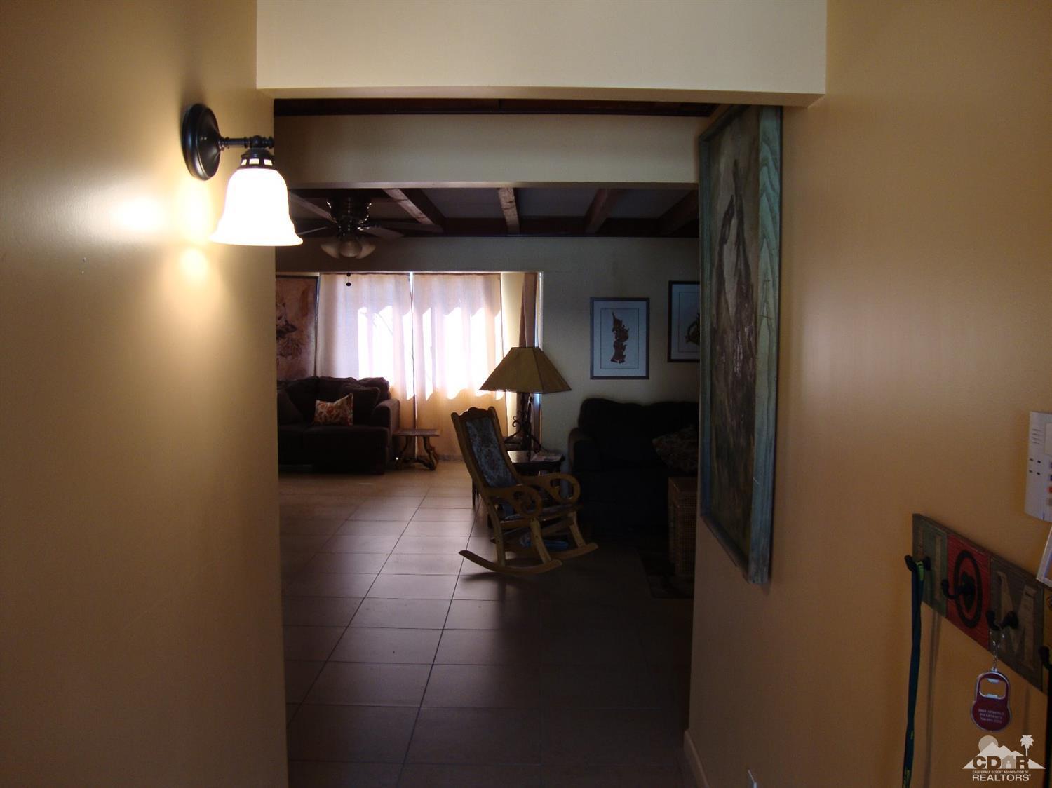 66671 San Rafael Road Desert Hot Springs, CA 92240 - Photo 6 of 36 a living room with furniture and a chandelier