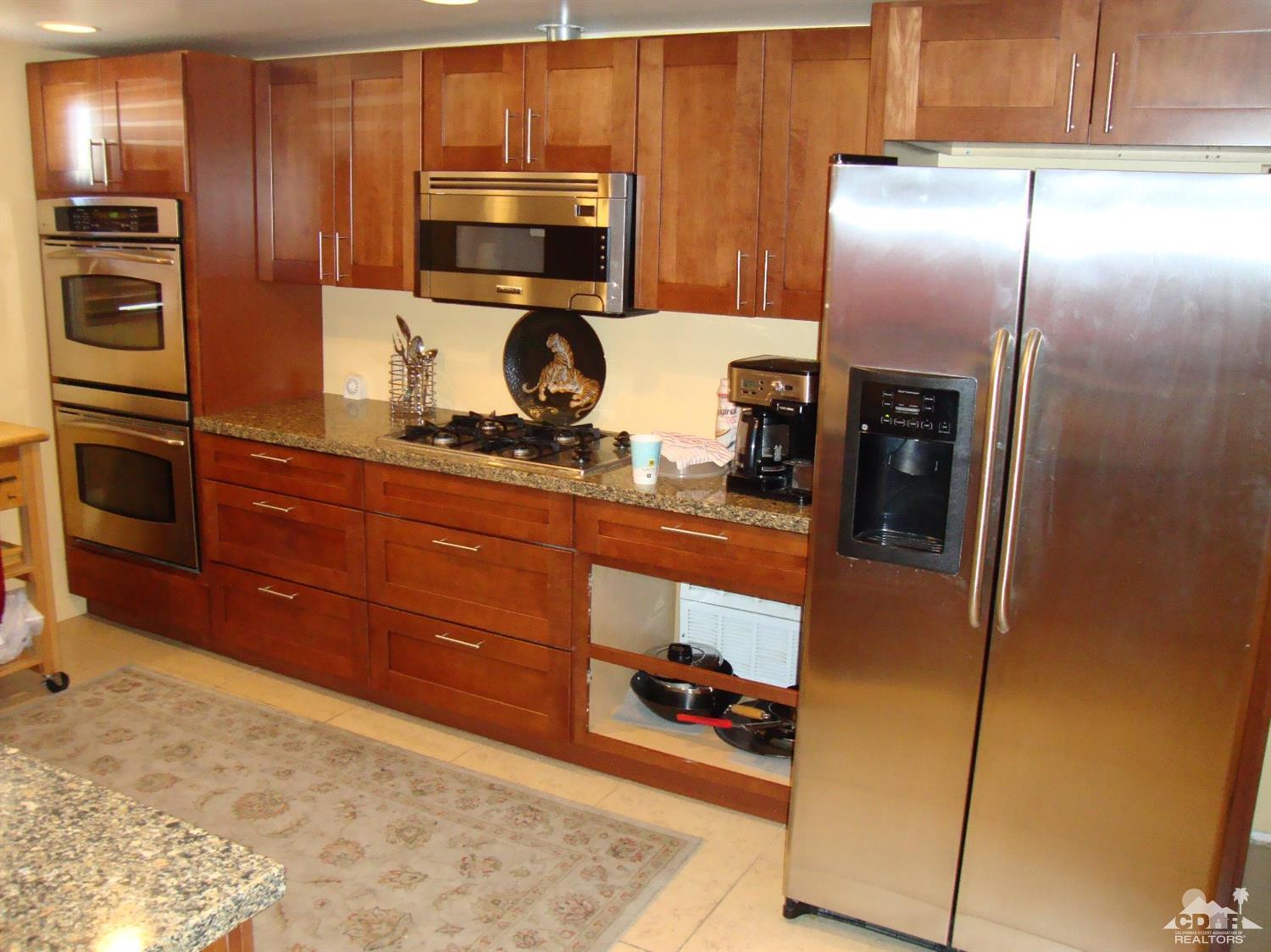 66671 San Rafael Road Desert Hot Springs, CA 92240 - Photo 10 of 36 a kitchen with a refrigerator and a stove