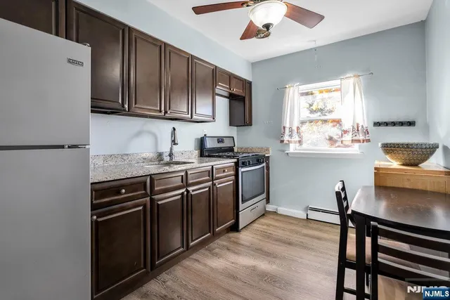 a kitchen with stainless steel appliances granite countertop a stove sink and cabinets