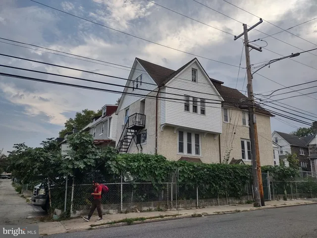a front view of a house with a tree in front