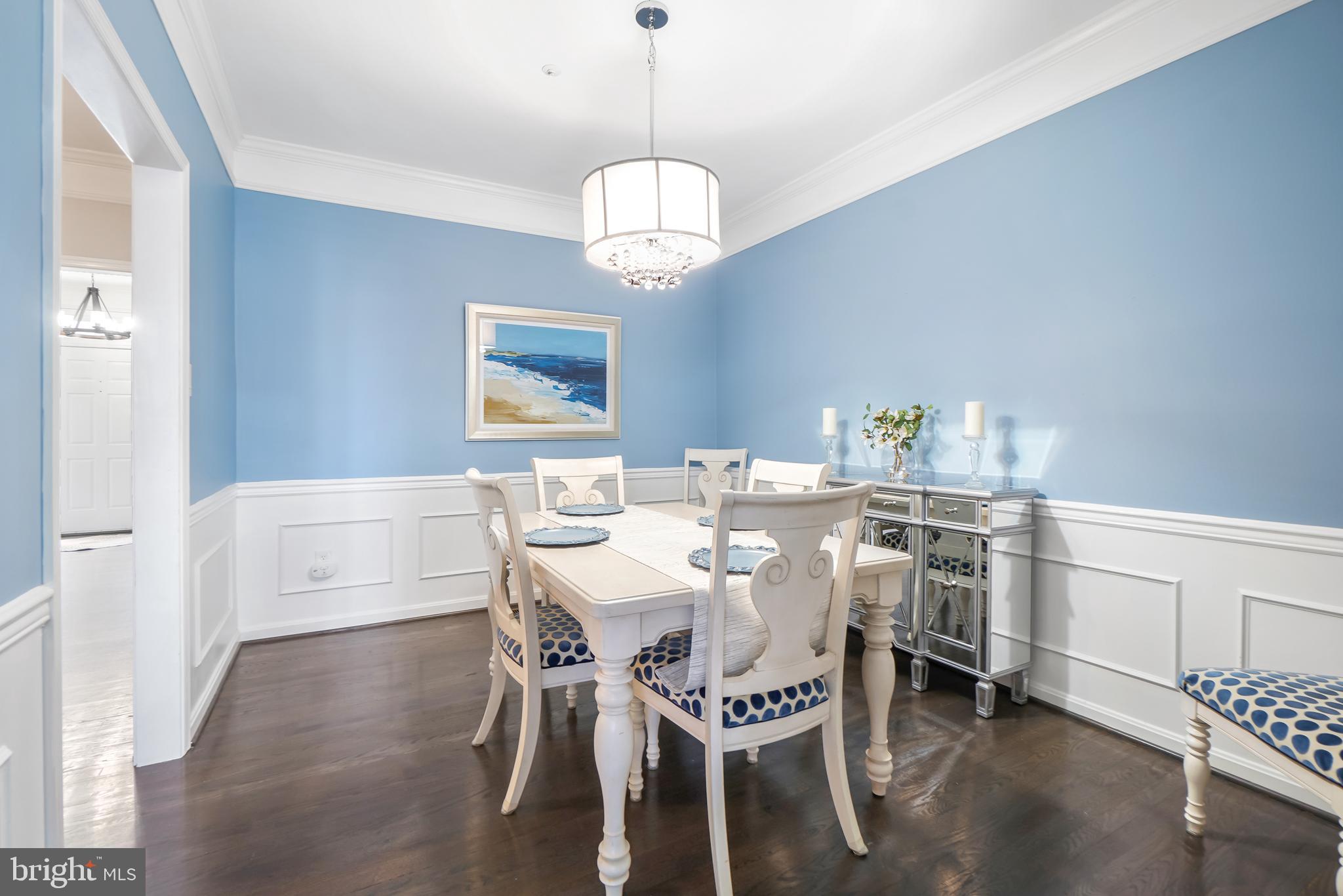 17963 Dumfries Circle Olney, MD 20832 - Photo 12 of 42 a dining room with wooden floor a chandelier a wooden table and chairs
