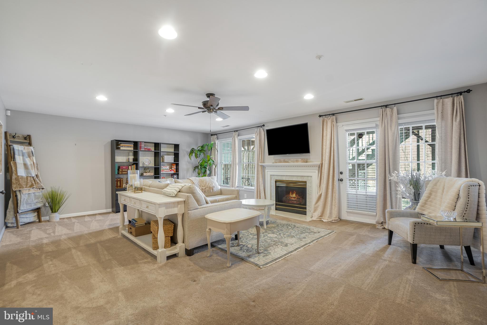 17963 Dumfries Circle Olney, MD 20832 - Photo 28 of 42 a living room with furniture a fireplace and a flat screen tv
