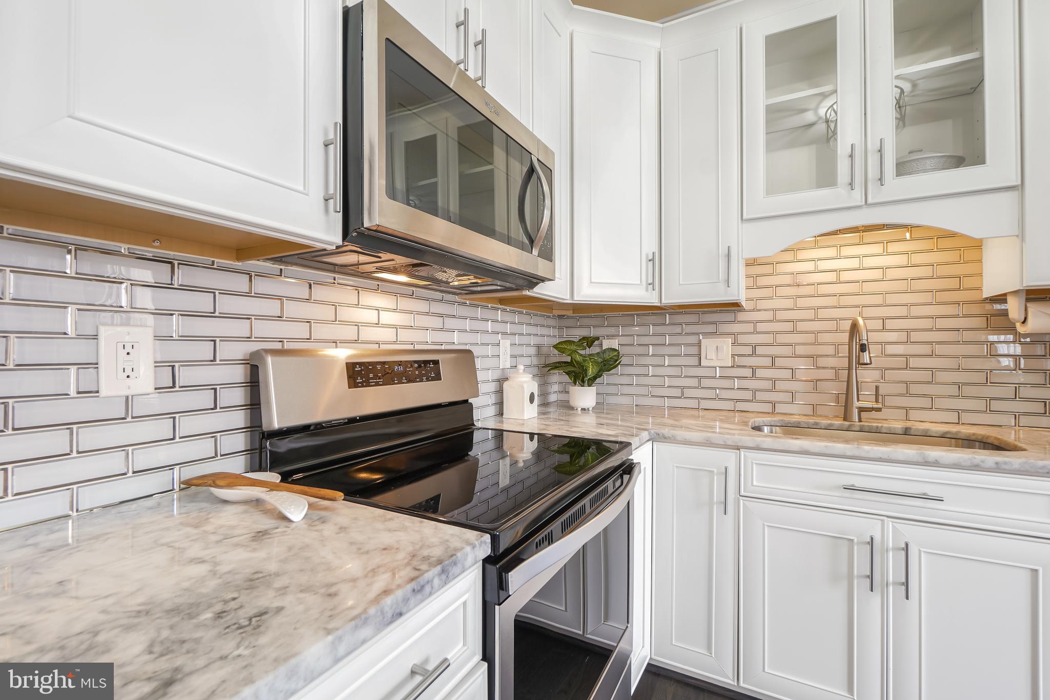 17963 Dumfries Circle Olney, MD 20832 - Photo 7 of 42 a kitchen with granite countertop a stove sink and cabinets