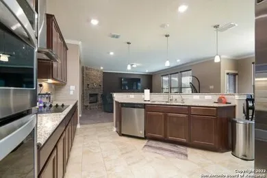 a kitchen with stainless steel appliances granite countertop a sink a stove and a wooden floors