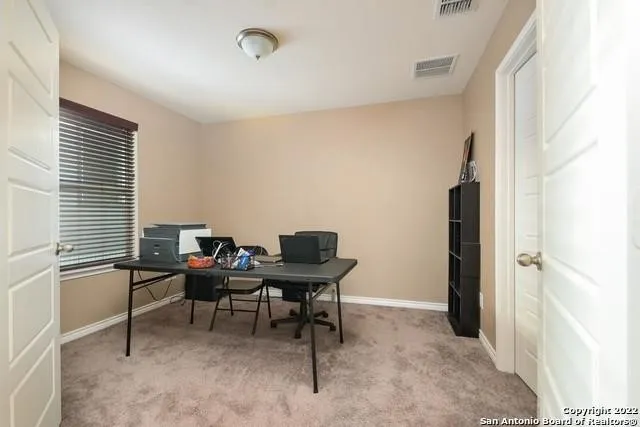 a view of a workspace with furniture and a window