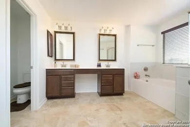 a bathroom with a bathtub sink and mirror