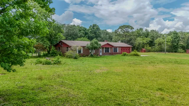 an aerial view of residential house with pool and trees all around