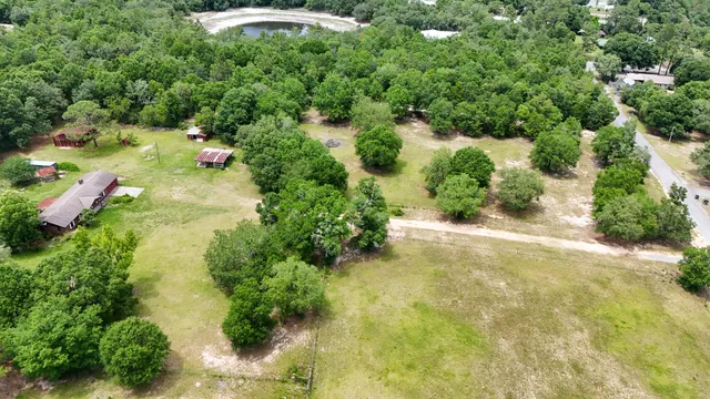 an aerial view of residential house with outdoor space and trees all around