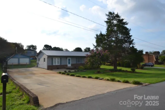 a front view of a house with a yard and trees