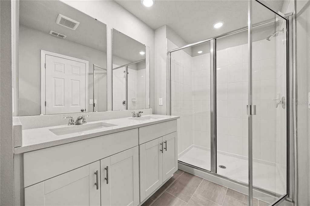 431 Legacy Loop Davenport, FL 33896 - Photo 11 of 25 a bathroom with a double vanity sink mirror and shower
