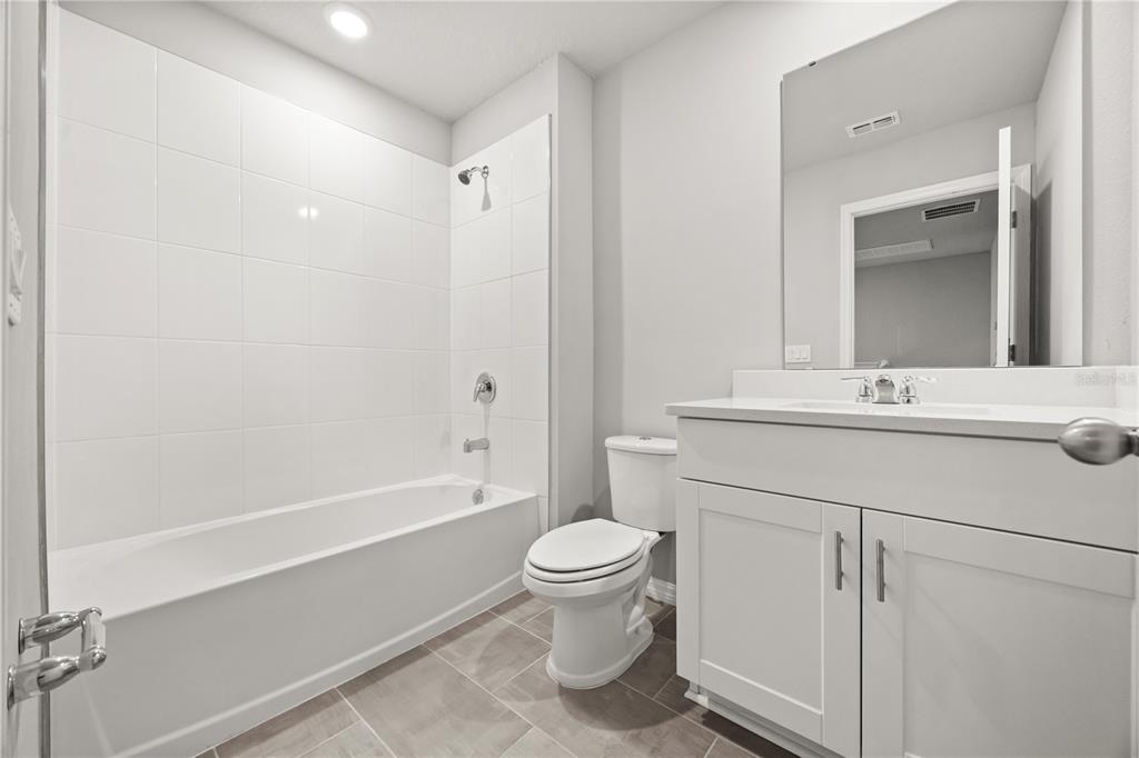 431 Legacy Loop Davenport, FL 33896 - Photo 17 of 25 a bathroom with a sink a toilet and a mirror