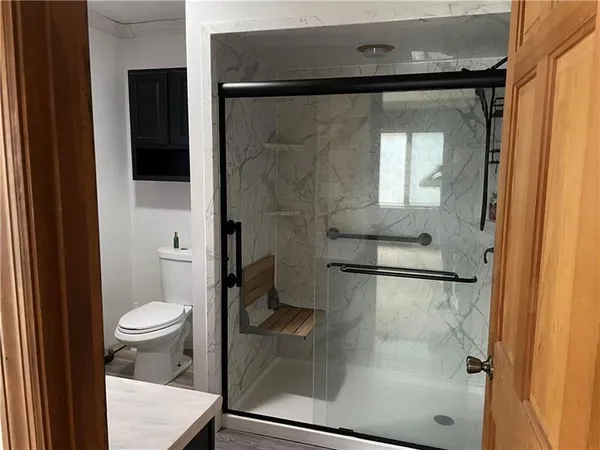 a bathroom with a toilet and a shower