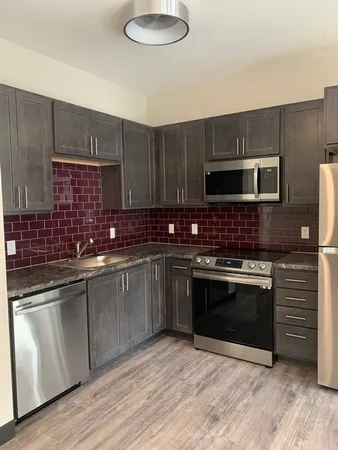 a kitchen with granite countertop a stove sink and cabinets