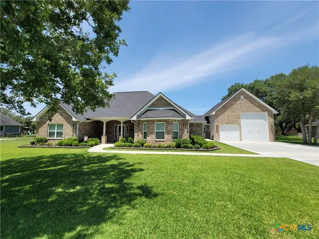 a front view of a house with a yard and trees